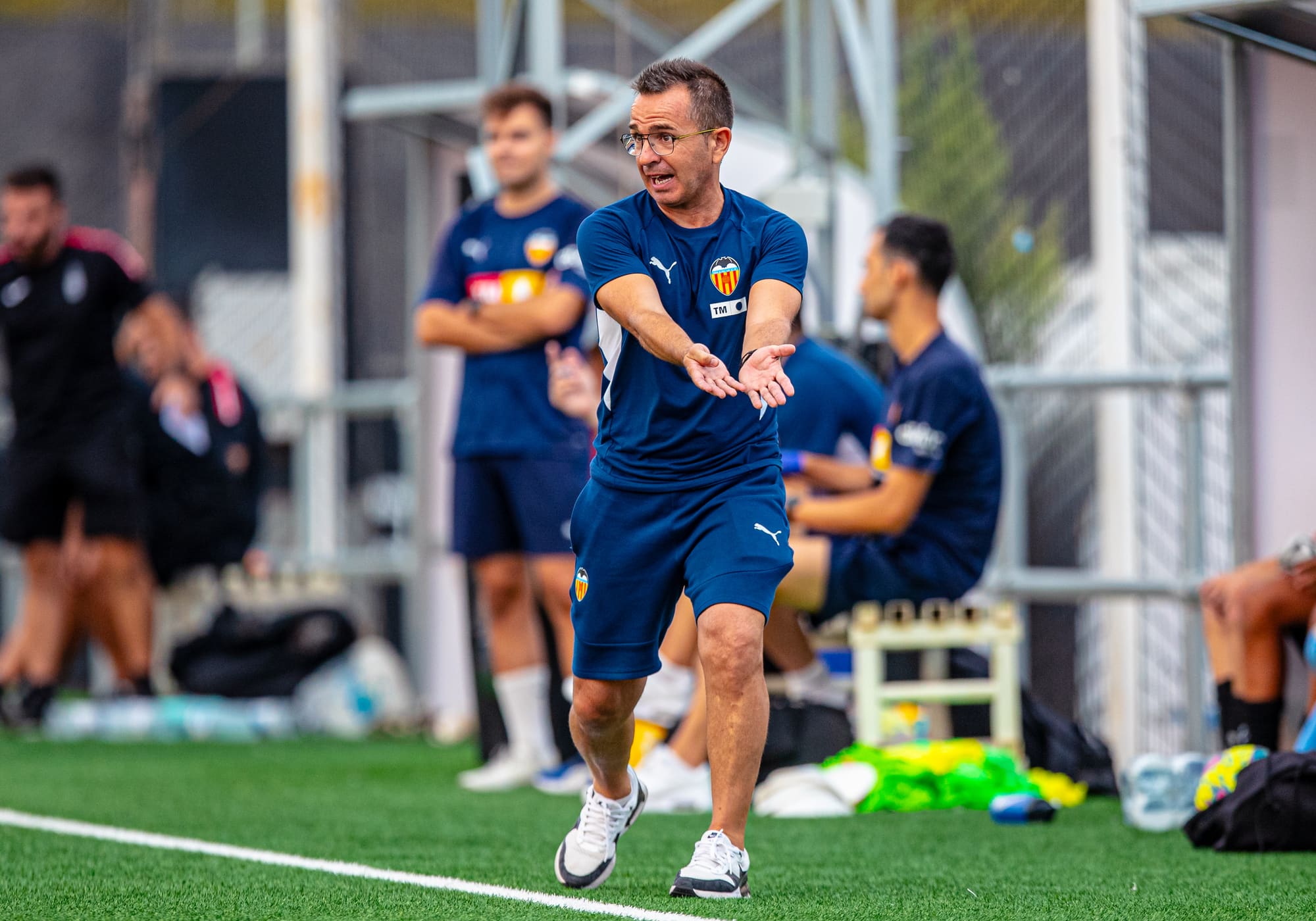 A Valencia academy coach giving instructions during a session